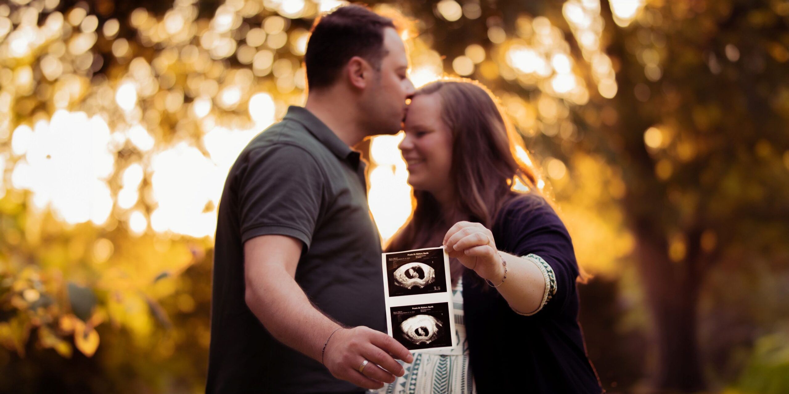 Man h&auml;lt die Hand seiner schwangeren Frau und hat ein Ultraschallbild des Babys in der Hand - Hamid Afzali &ndash; Hochzeitsfotograf und Hochzeitsvideograf